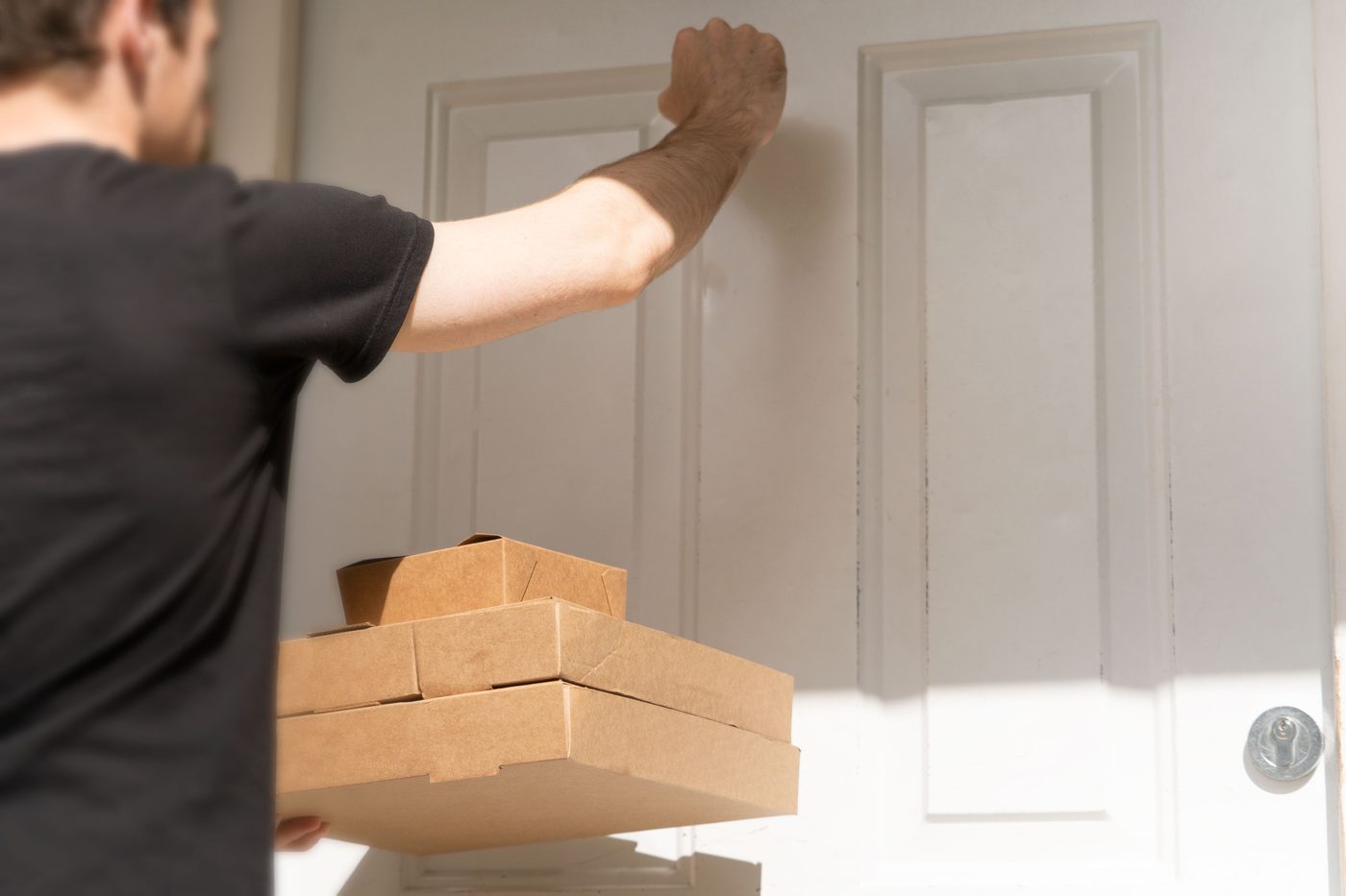 Delivery driver dropping off packages at a front door